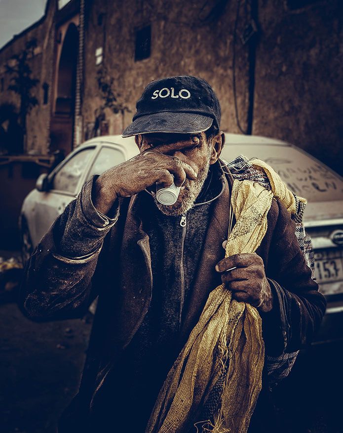 A man in a SOLO cap sips from a small cup